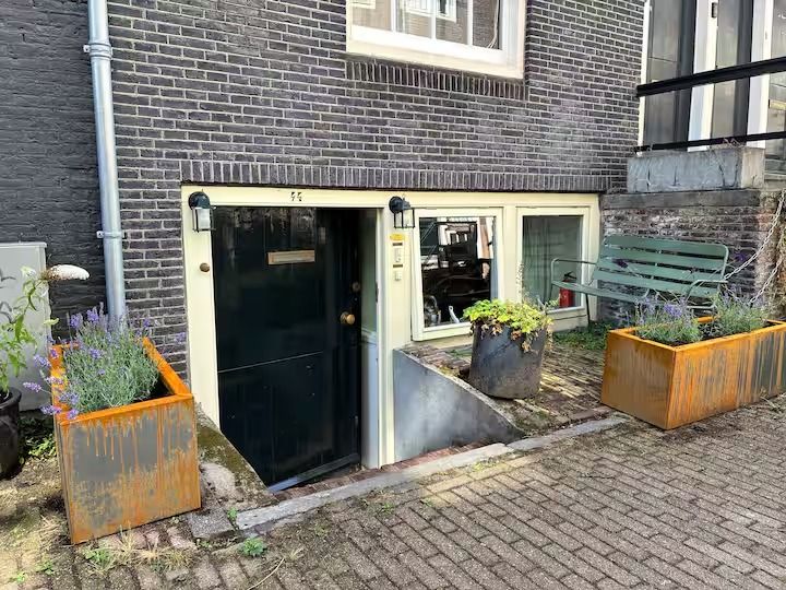De voordeur van het souterrain met plantenbakken